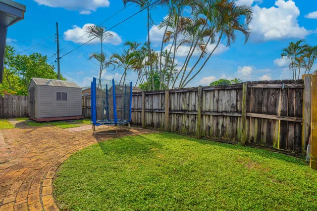 a view of a backyard with potted plants and wooden fence