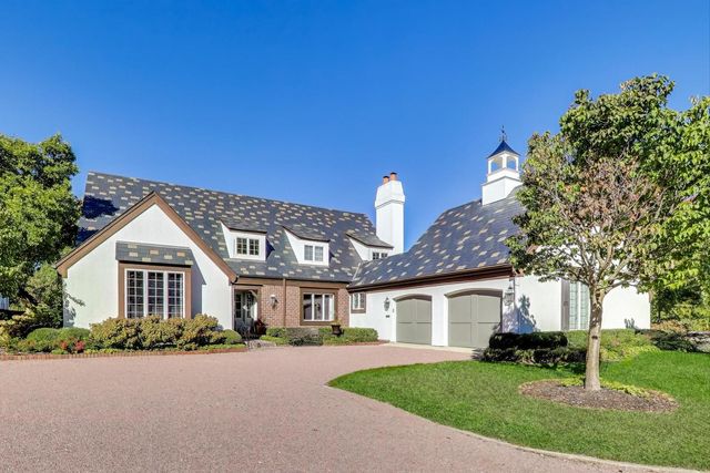 a front view of a house with a garden and trees