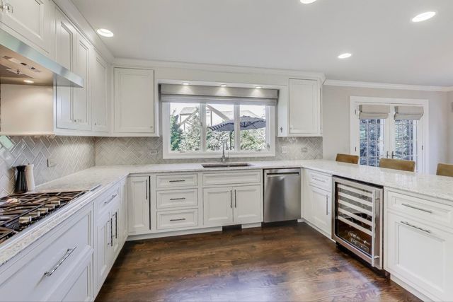 a kitchen with a stove a sink and a window