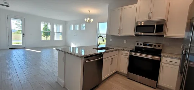a kitchen with stainless steel appliances granite countertop a sink stove and microwave
