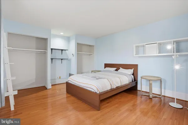 a large bed sitting in a room with a fireplace and wooden floor