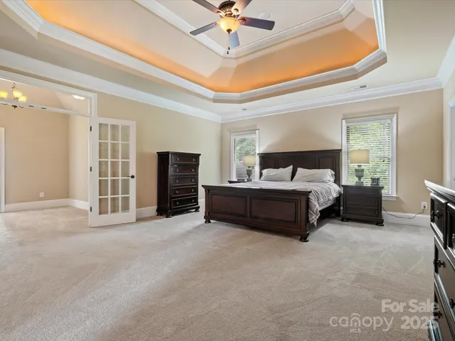 a spacious bedroom with a bed and a ceiling fan
