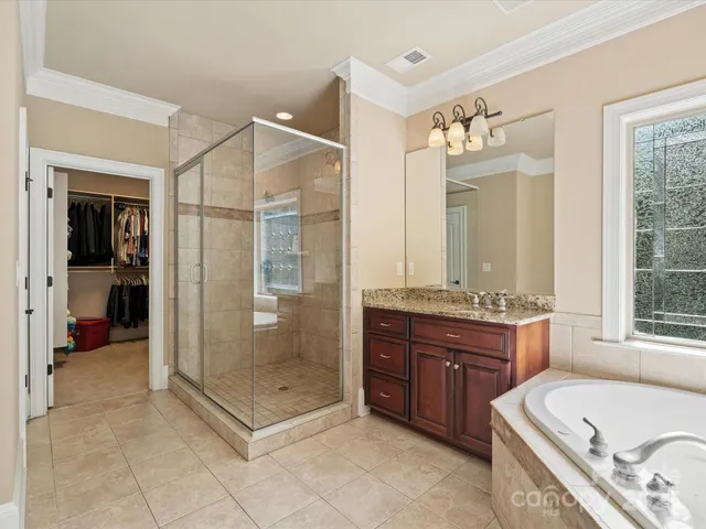 a bathroom with a tub sink shower and mirror