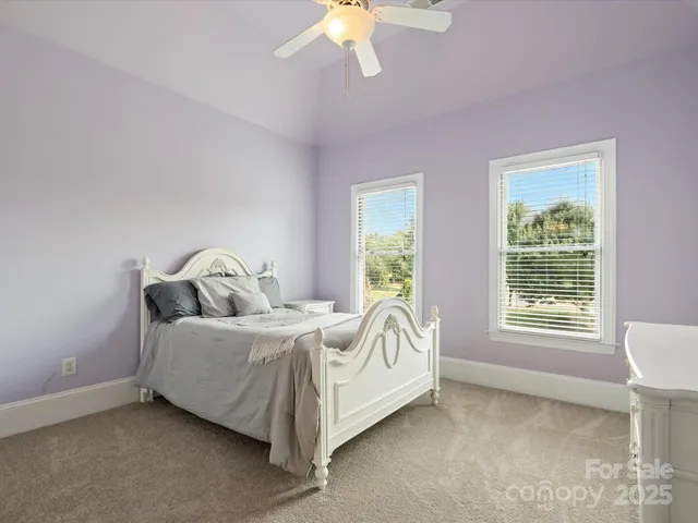 a bed sitting in a bedroom next to a window