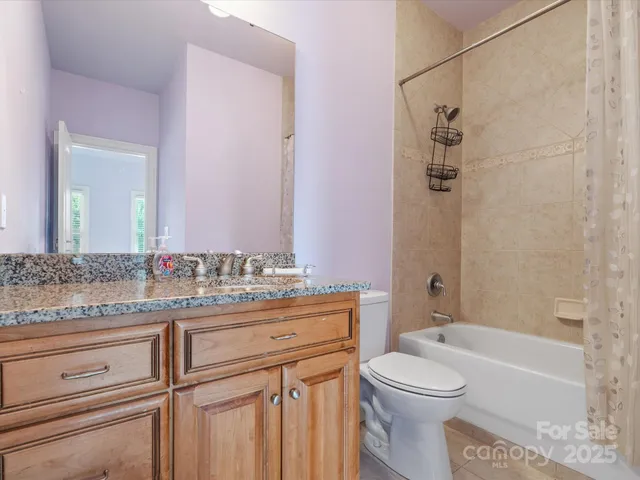 a bathroom with a granite countertop toilet sink and mirror