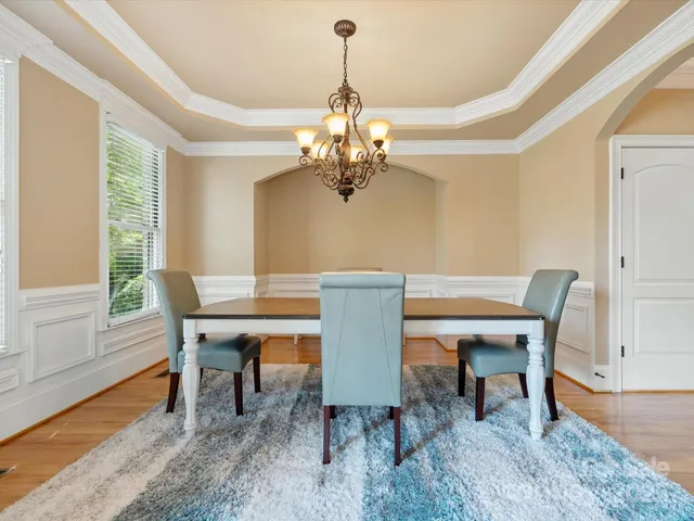 a dining room with furniture a chandelier and wooden floor