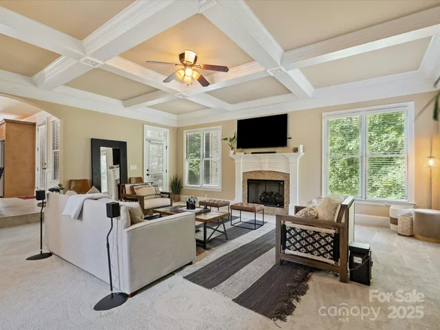 a living room with furniture fireplace and a large window