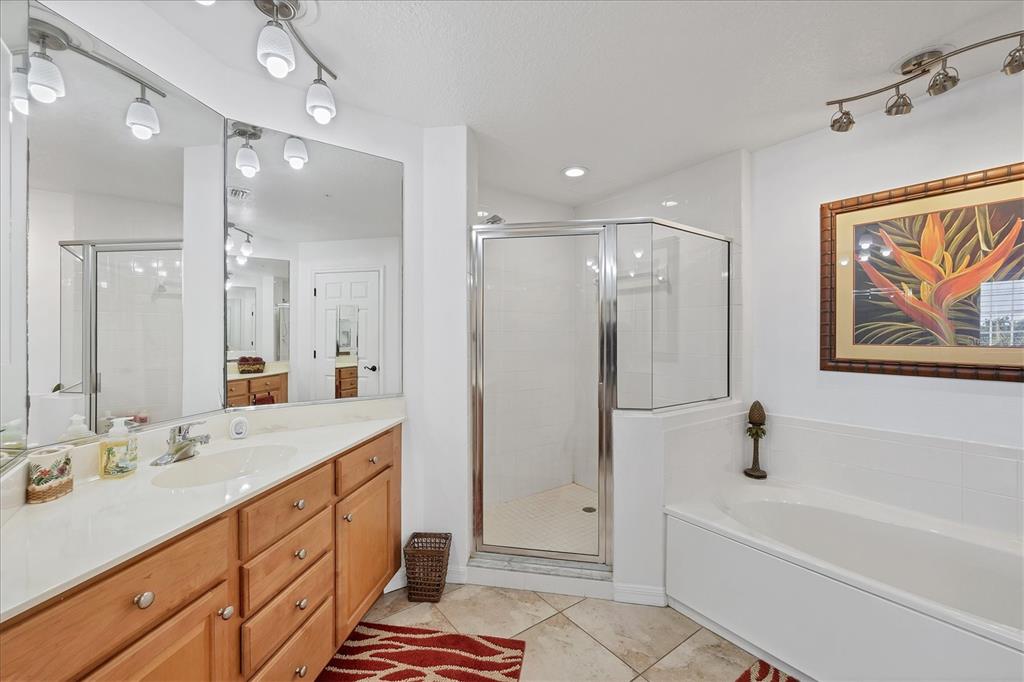 13113 Gasparilla Road, Unit A305 Placida, FL 33946 - Photo 16 of 29 a bathroom with a tub a sink double vanity and a glass door shower
