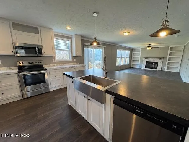 a kitchen with stainless steel appliances granite countertop a sink a stove and a wooden floors