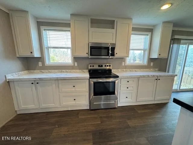 a kitchen with stainless steel appliances a stove sink and microwave