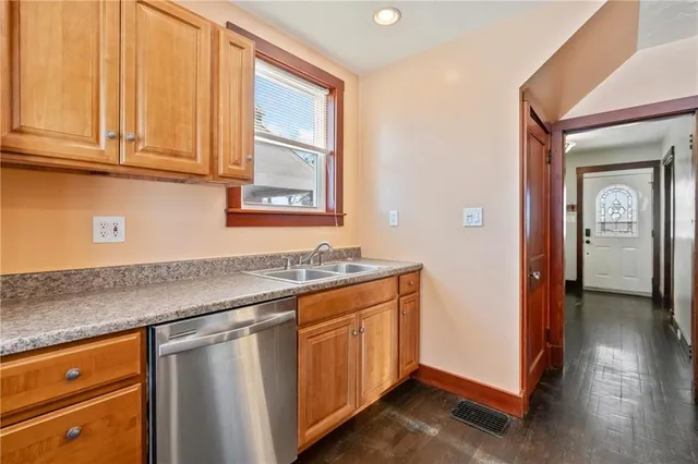 a kitchen with stainless steel appliances granite countertop a sink and cabinets with wooden floor