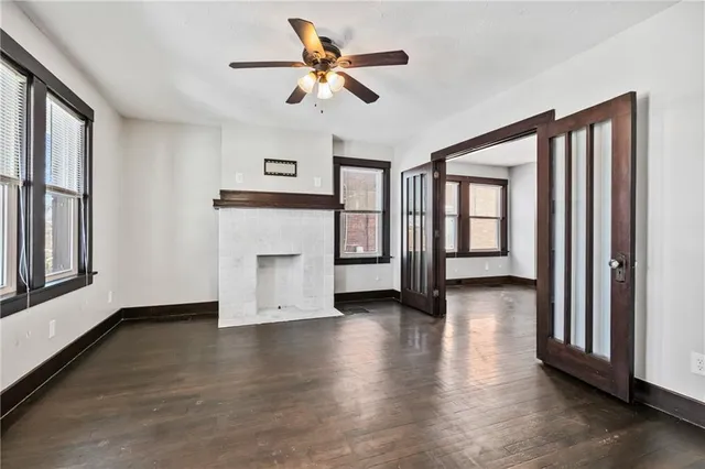 a view of an empty room with a window and wooden floor