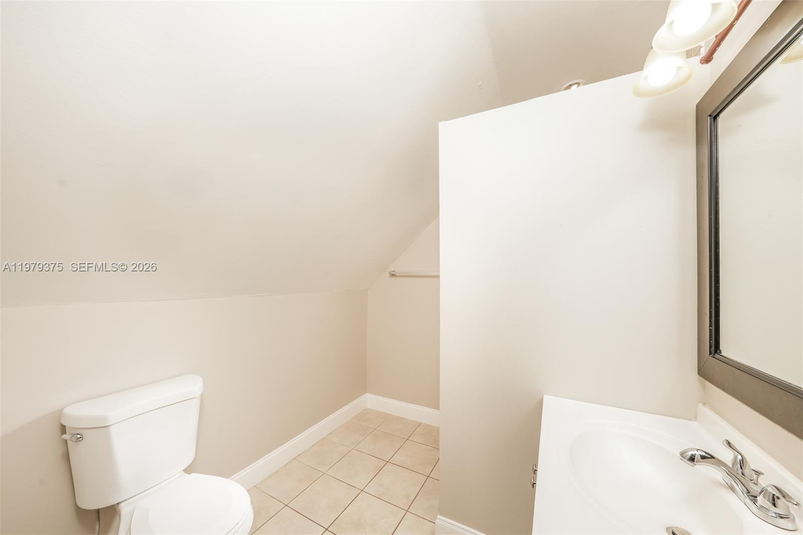 5227 Adams Road Delray Beach, FL 33484 - Photo 16 of 18 a white toilet sitting next to a bathroom sink