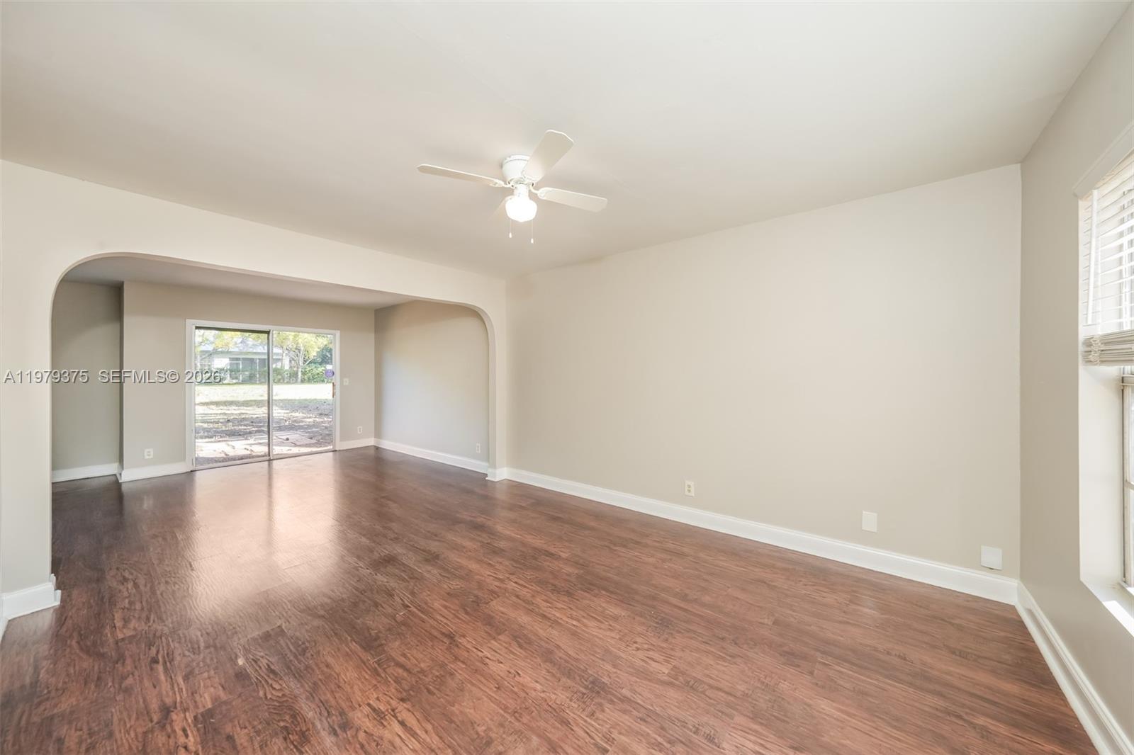 5227 Adams Road Delray Beach, FL 33484 - Photo 2 of 18 an empty room with wooden floor and windows