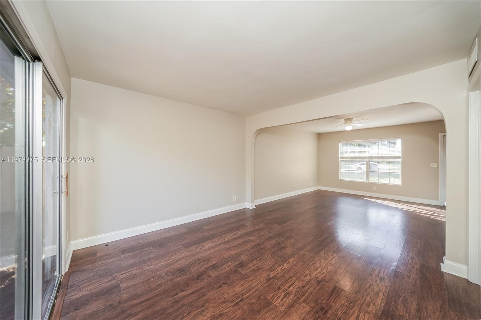 5227 Adams Road Delray Beach, FL 33484 - Photo 5 of 18 an empty room with wooden floor and windows