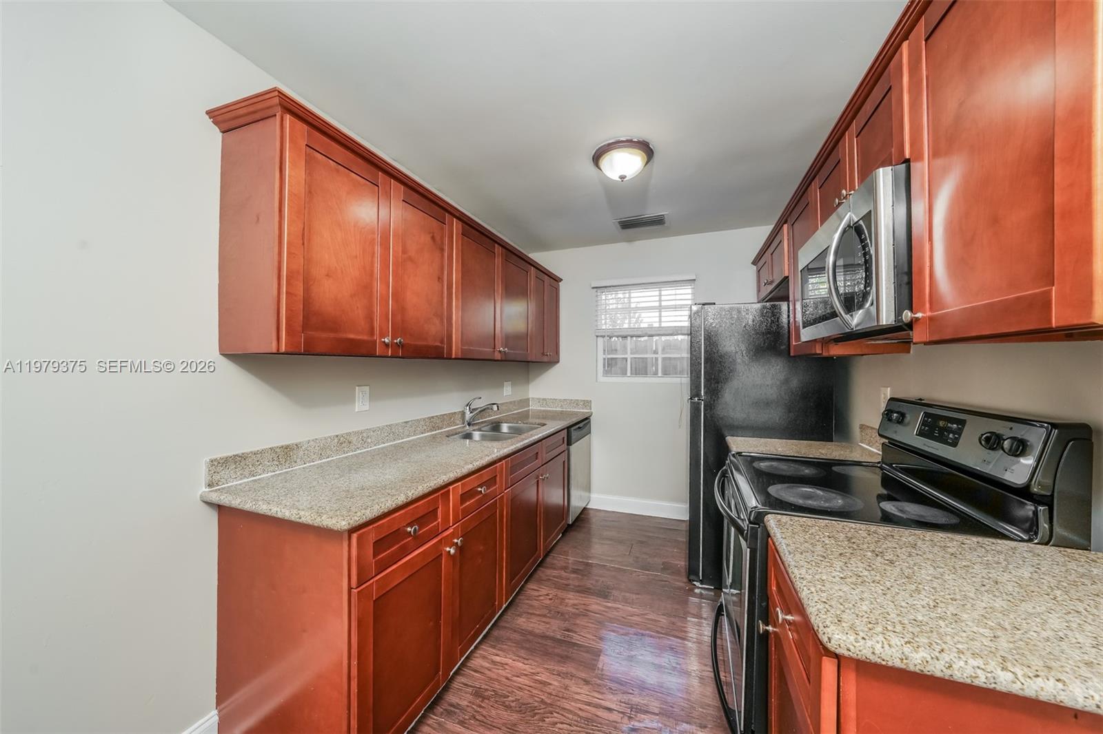 5227 Adams Road Delray Beach, FL 33484 - Photo 8 of 18 a kitchen with stainless steel appliances granite countertop a stove a sink dishwasher and a refrigerator