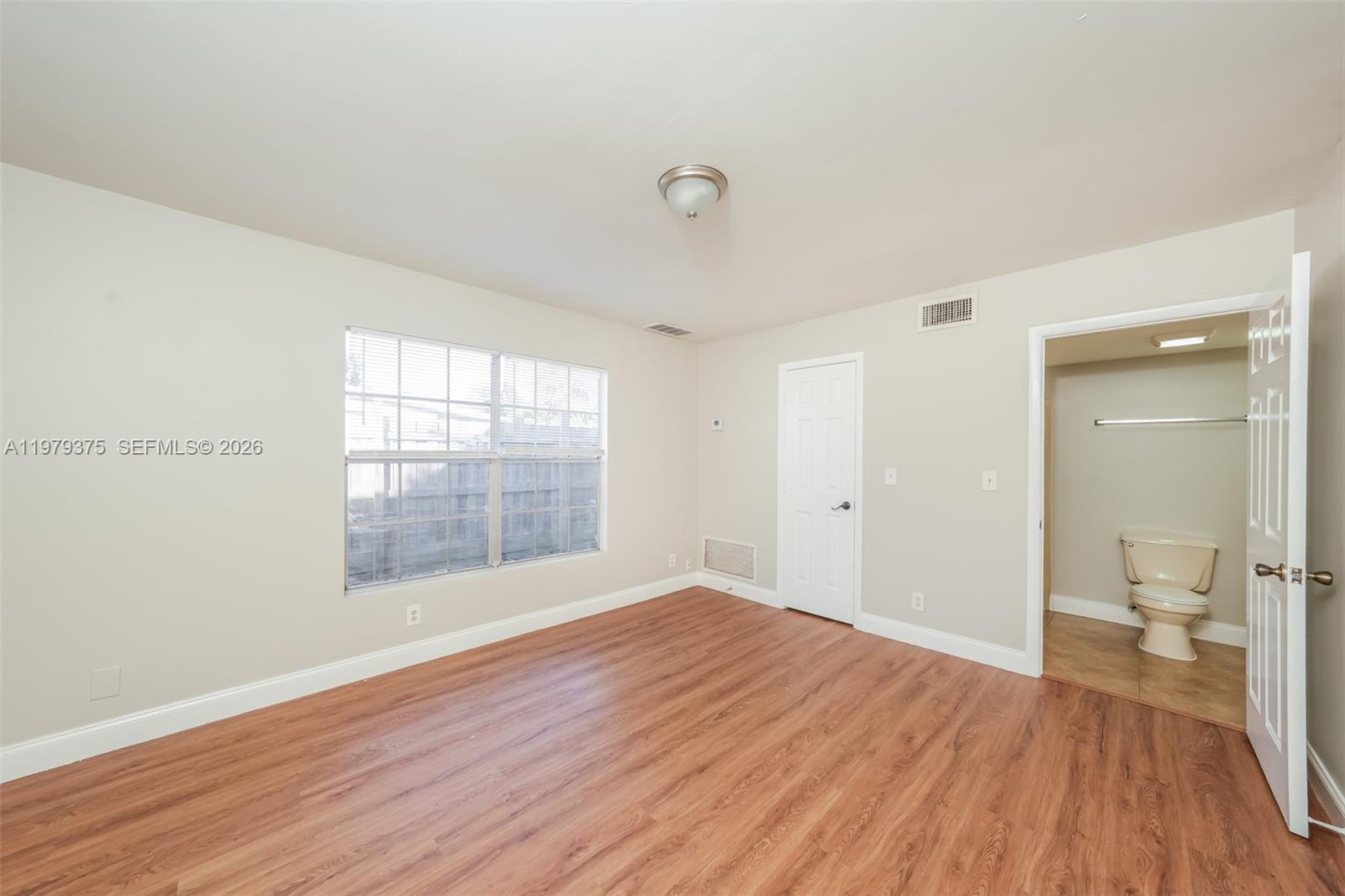5227 Adams Road Delray Beach, FL 33484 - Photo 9 of 18 a view of a room with wooden floor and a window