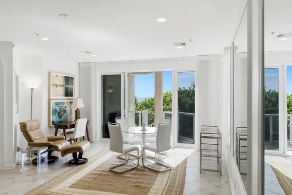 a living room with furniture large window and dining table