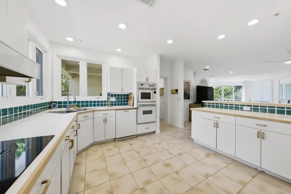 a kitchen with white cabinets and white appliances