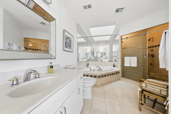 a bathroom with a granite countertop sink a toilet and shower