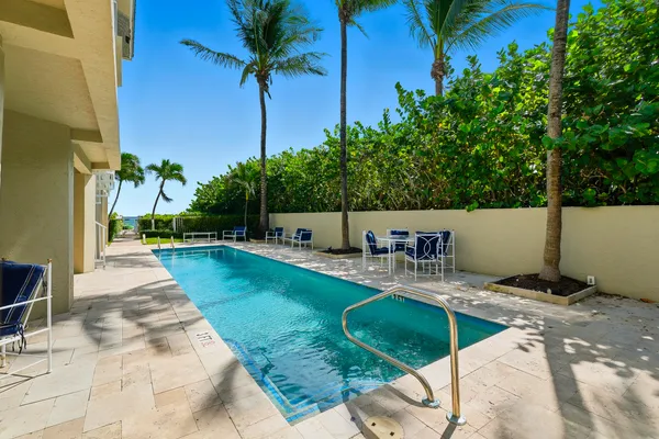 a view of a house with pool and chairs