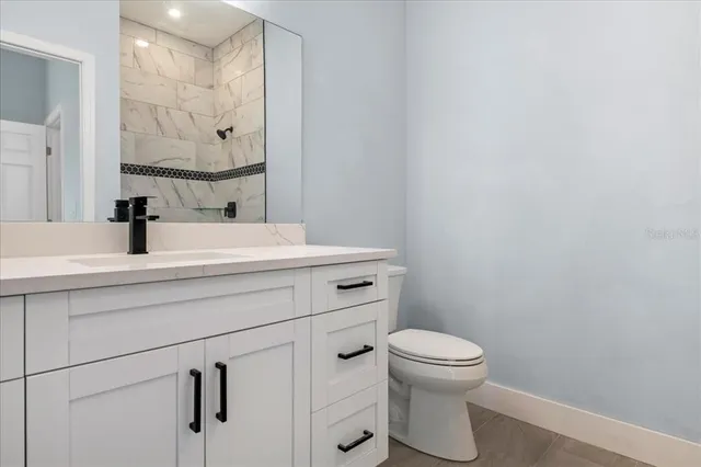 a bathroom with a sink a toilet and a mirror