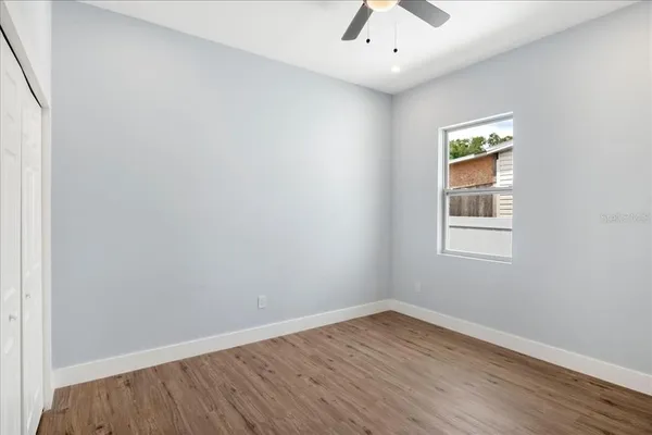 an empty room with a window and wooden floor