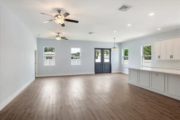 a view of an empty room with a window and wooden floor