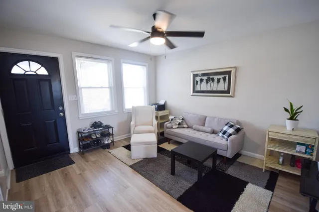 a living room with furniture a wooden floor and a large window
