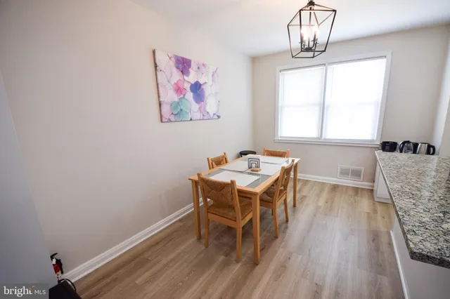 a view of a dining room with furniture a chandelier and wooden floor