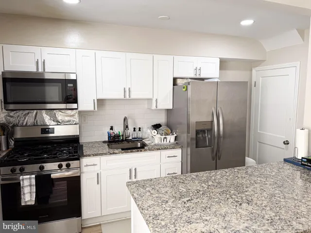 a kitchen with white cabinets and appliances