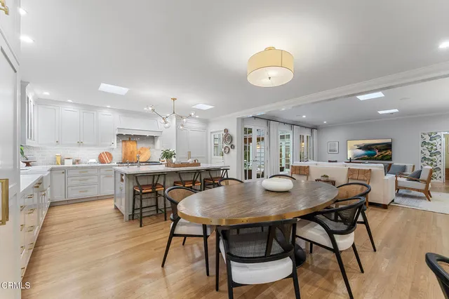a kitchen with a table chairs sink and cabinets