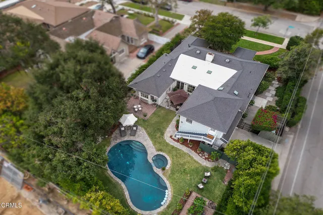a view of a patio with couches table and chairs under an umbrella with a barbeque