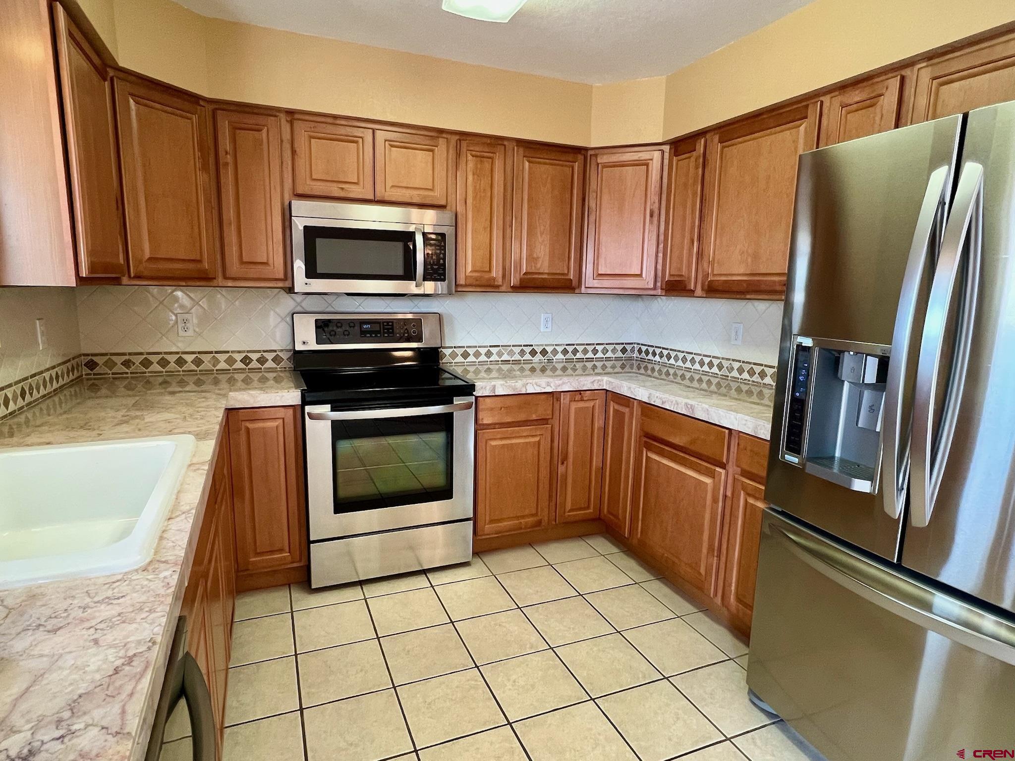 485 1740th Road Delta, CO 81416 - Photo 13 of 37 a kitchen with stainless steel appliances granite countertop a refrigerator sink and stove