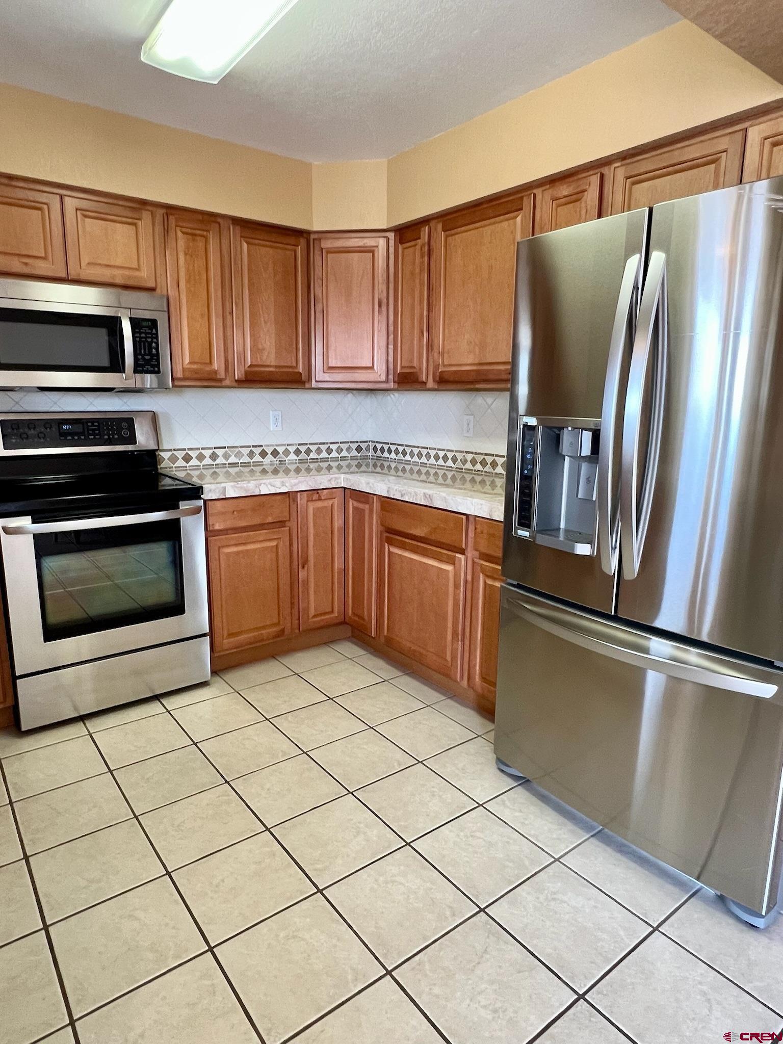 485 1740th Road Delta, CO 81416 - Photo 14 of 37 a kitchen with stainless steel appliances granite countertop a refrigerator sink and cabinets