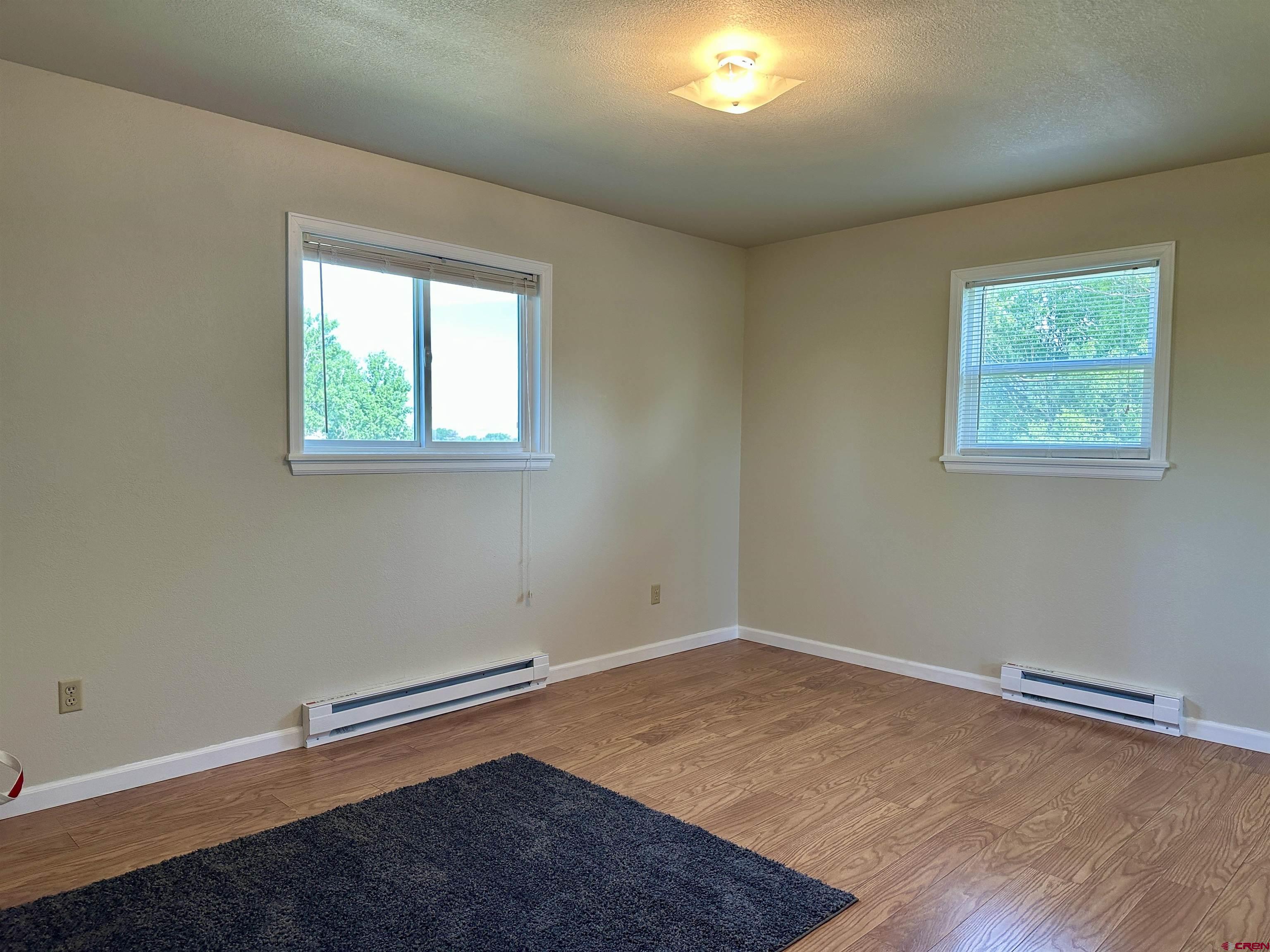 485 1740th Road Delta, CO 81416 - Photo 21 of 37 an empty room with wooden floor and windows