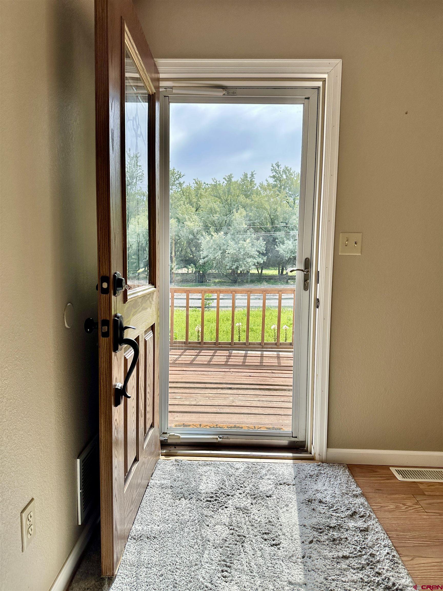 485 1740th Road Delta, CO 81416 - Photo 4 of 37 an empty room with floor to ceiling windows and a rug