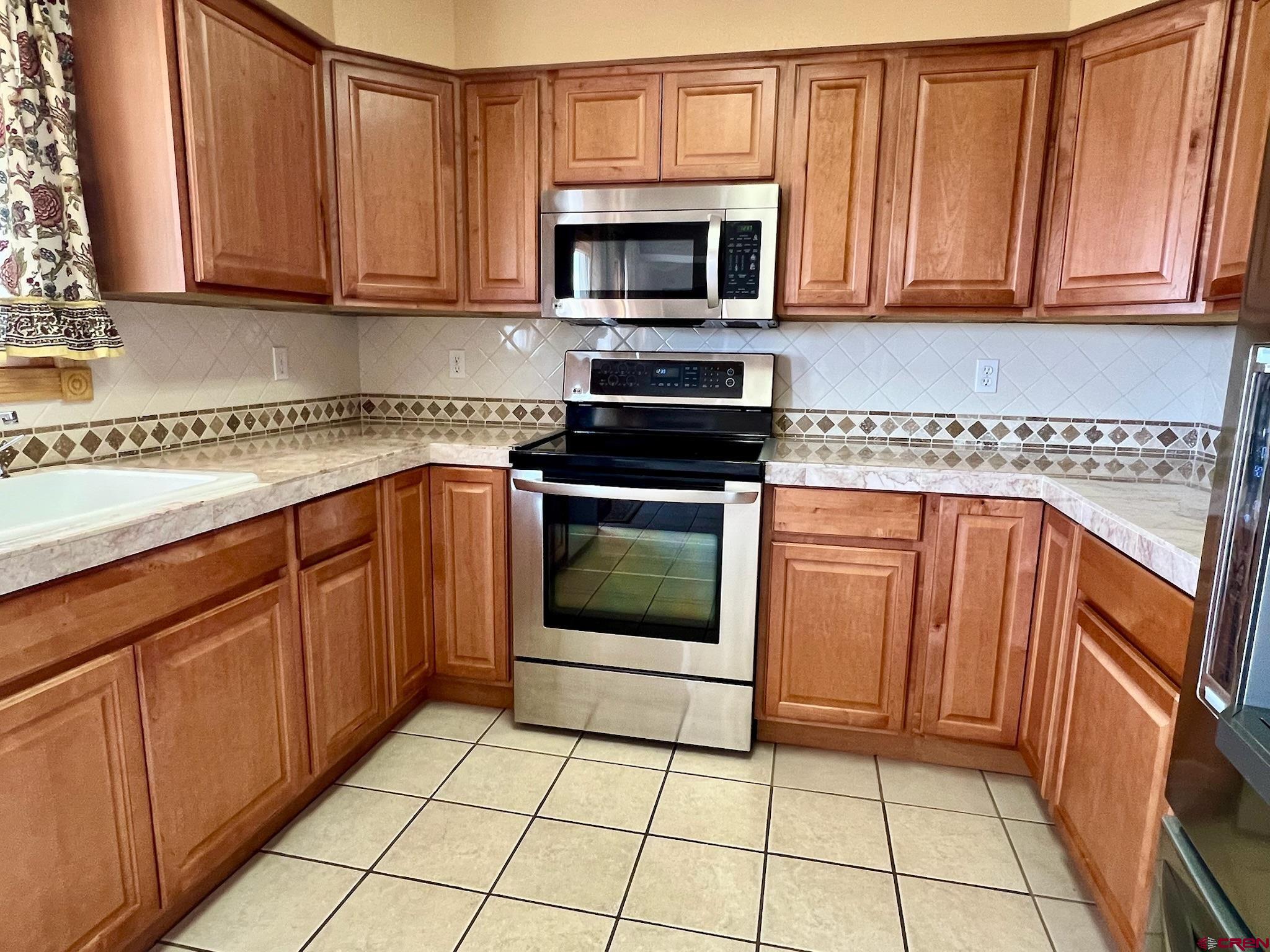 485 1740th Road Delta, CO 81416 - Photo 10 of 37 a kitchen with granite countertop a stove top oven microwave and cabinets