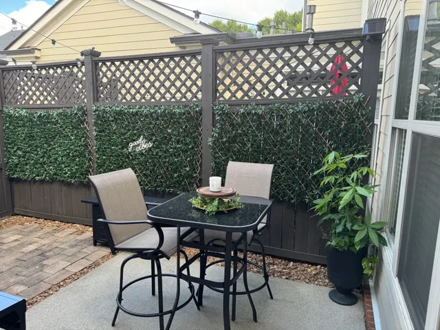 a patio table and chairs with potted plants