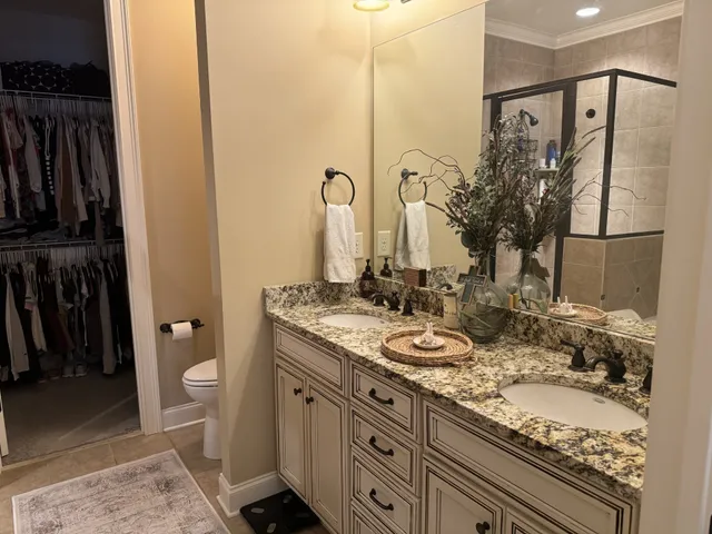 a bathroom with a granite countertop sink a toilet and a shower curtain