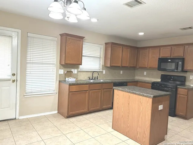 a kitchen with stainless steel appliances granite countertop a refrigerator sink and stove