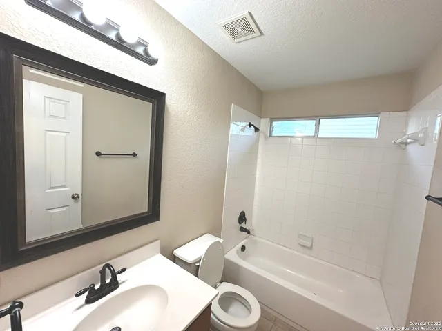 a en suite bathroom with a bathtub double vanity sink and mirror
