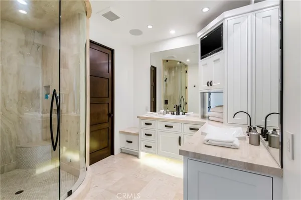 a bathroom with a double vanity sink mirror and shower