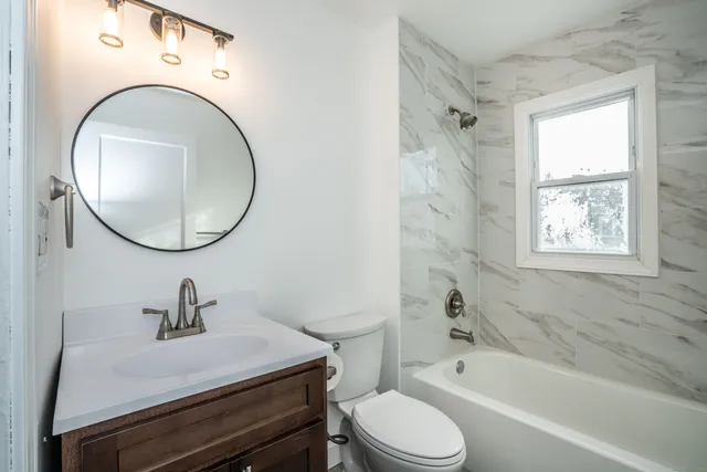 a bathroom with a sink a toilet and a mirror