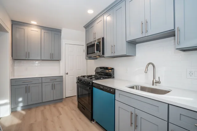 a kitchen with stainless steel appliances granite countertop a sink stove and cabinets