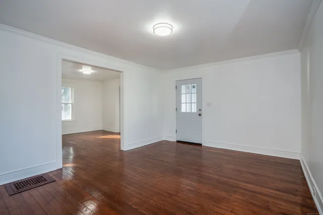 a view of an empty room with wooden floor