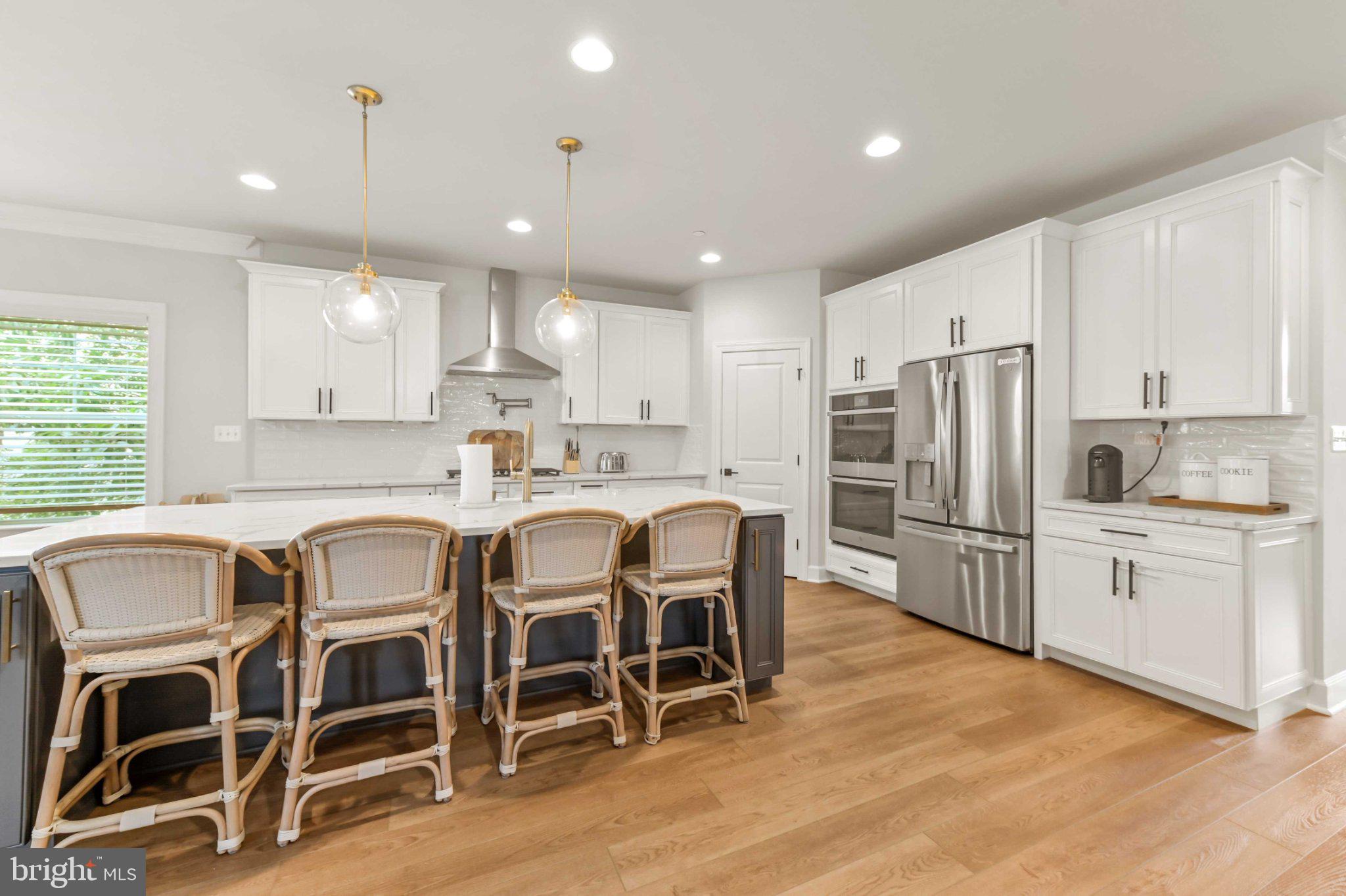 6310 Winters Lane Hanover, MD 21076 - Photo 12 of 76 a kitchen with refrigerator a sink and chairs