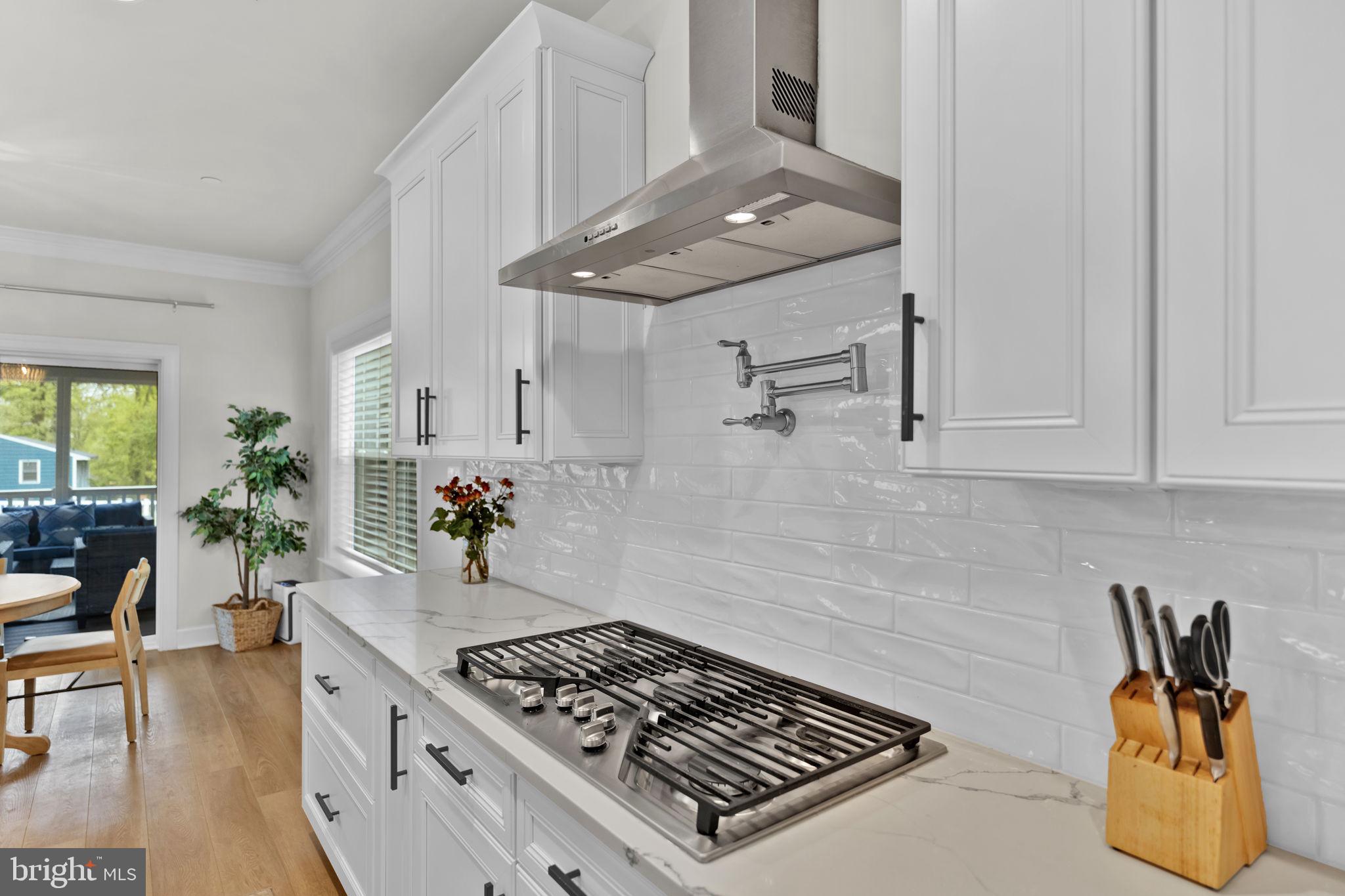 6310 Winters Lane Hanover, MD 21076 - Photo 19 of 76 a kitchen with granite countertop a stove and white cabinets