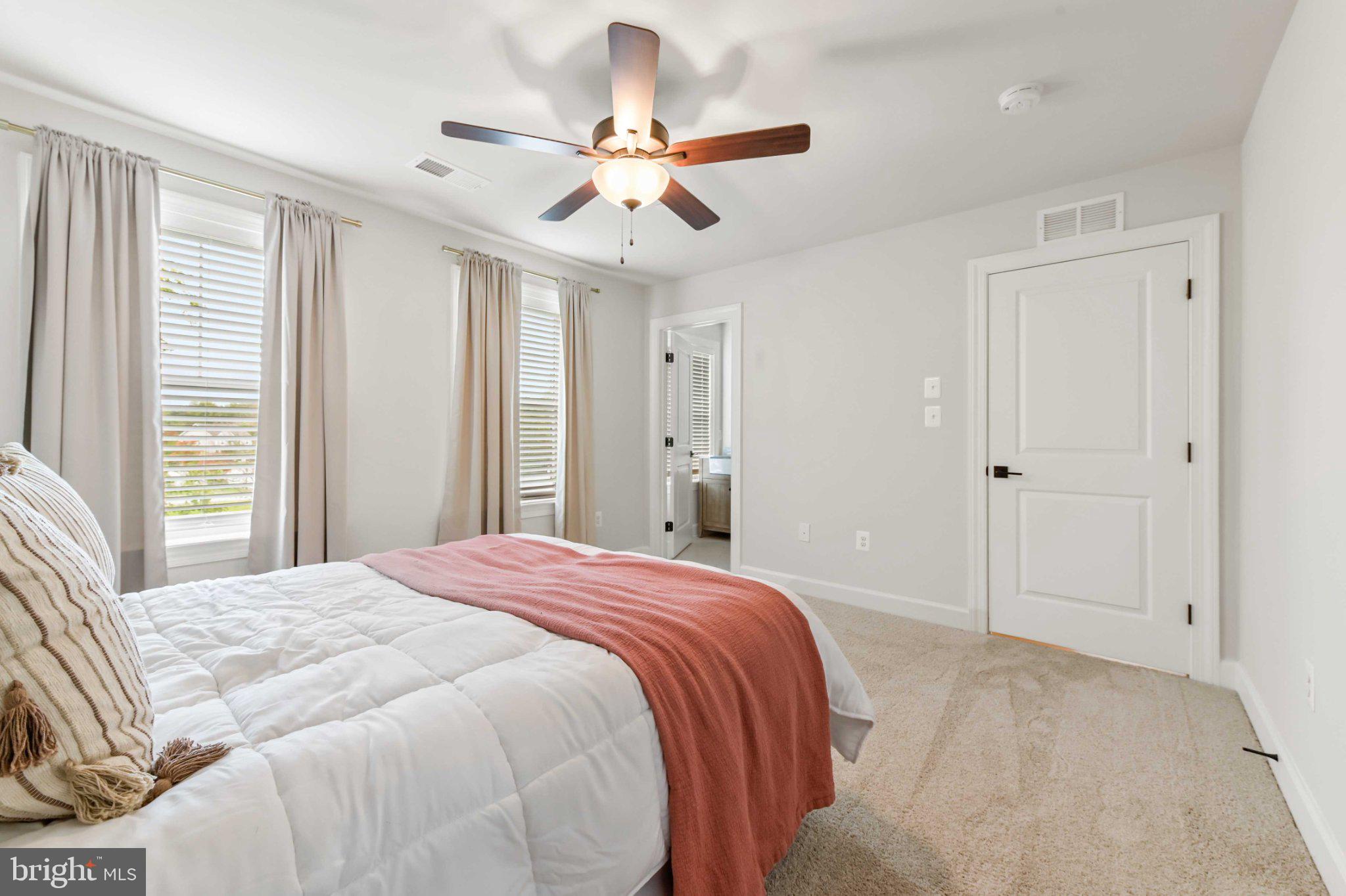 6310 Winters Lane Hanover, MD 21076 - Photo 37 of 76 a bedroom with a large bed window and a ceiling fan
