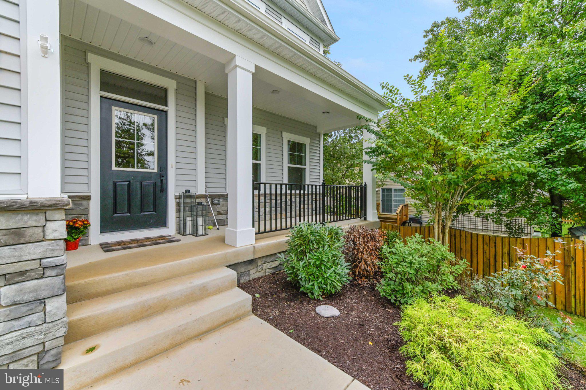 6310 Winters Lane Hanover, MD 21076 - Photo 4 of 76 a view of a house with potted plants and a large tree